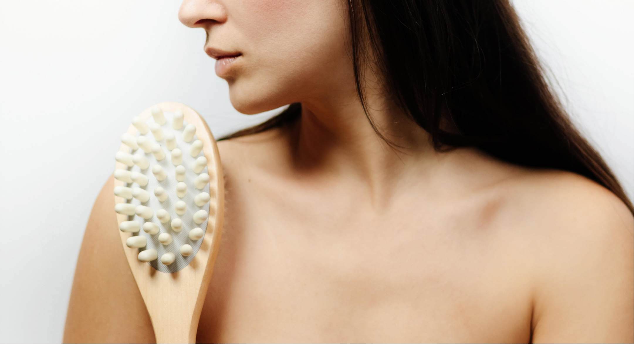 Image of woman using a massage brush to help reduce the appearance of cellulite
