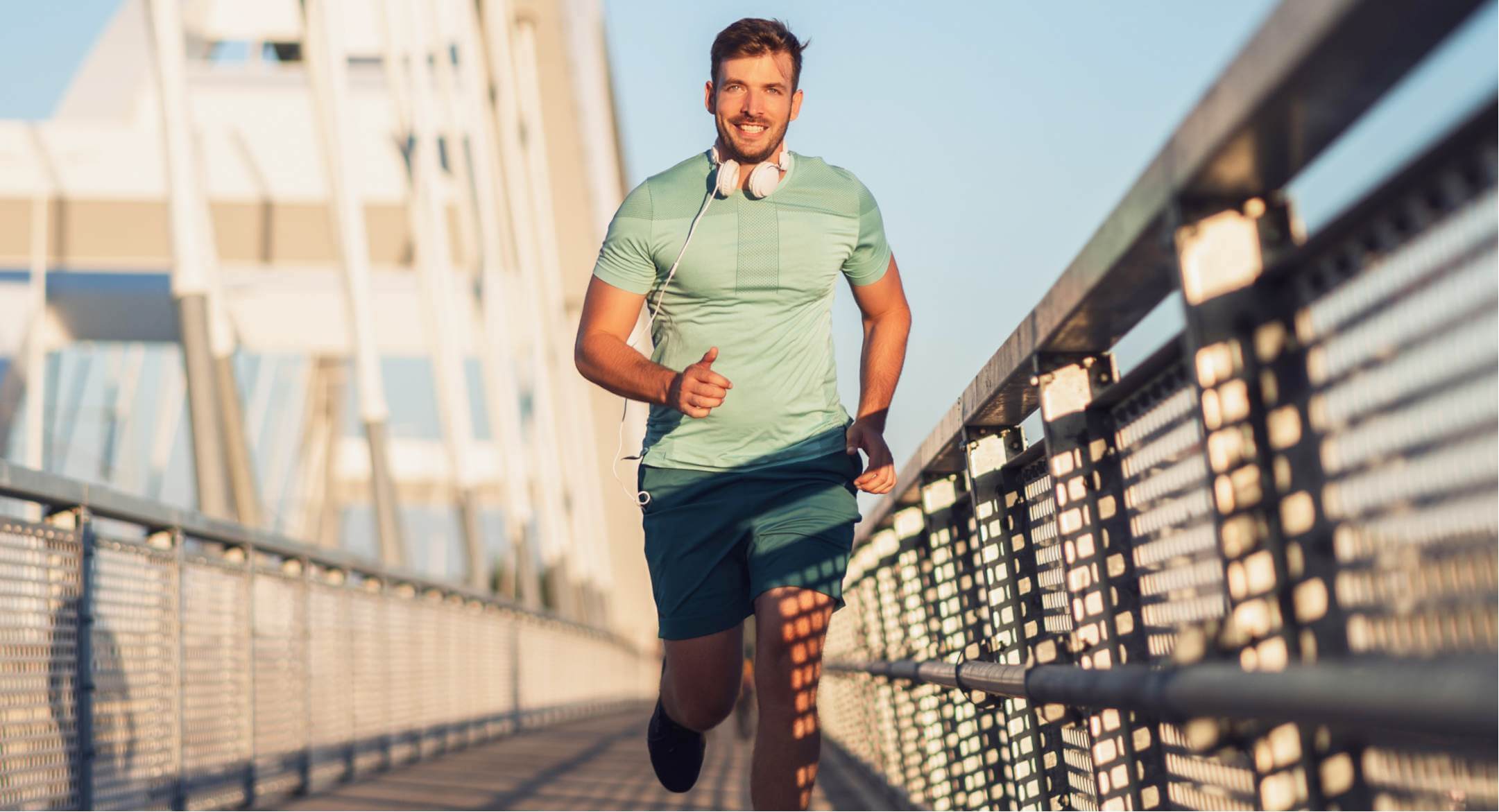 Image of man jogging across a bridge to get fit and lose weight.